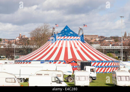 Lo zio Sam's American Circus big top e veicoli in un parco cittadino con alloggiamento in distanza. Nottingham, Inghilterra, Regno Unito Foto Stock