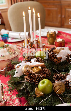 Dettaglio di un natale wrather su una tabella prevista per la cena di Natale con le candele e decorazioni. Il vasellame è un mix di Lunev Foto Stock