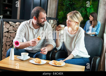 Giovane flirtare in un cafe, persone in background Foto Stock