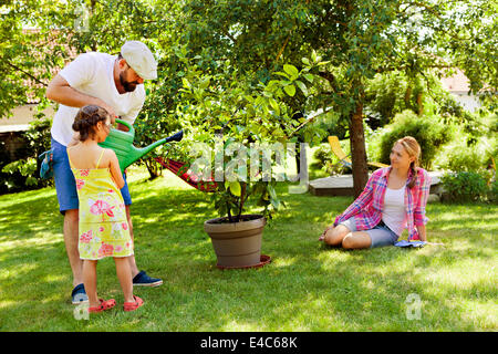 Padre e figlia del giardinaggio, madre sta guardando, Monaco di Baviera, Germania Foto Stock