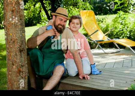 Padre e figlio di prendere una pausa nel giardino, Monaco di Baviera, Germania Foto Stock