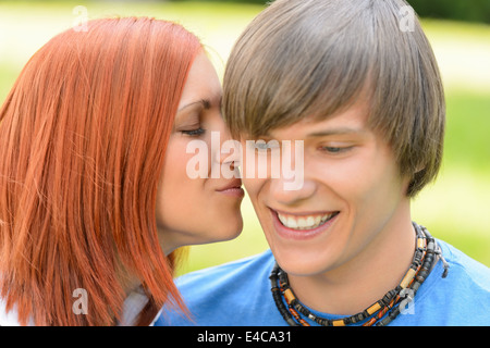 Amare giovane donna baciare Ragazzo della guancia giornata soleggiata close-up Foto Stock