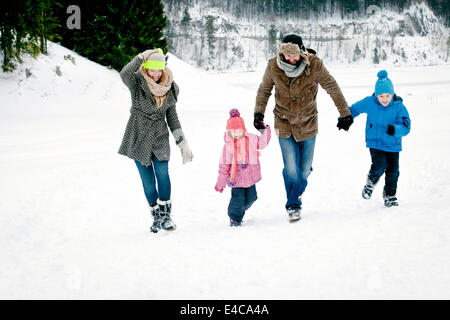 Famiglia con due bambini nel paesaggio innevato divertendosi, Baviera, Germania Foto Stock