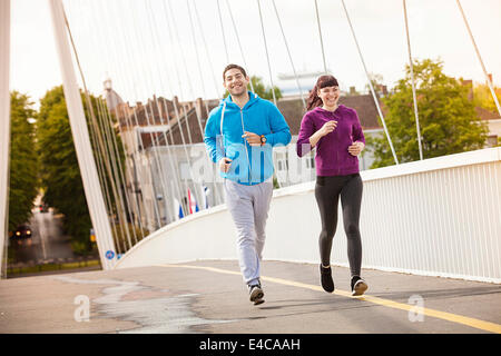 Coppia giovane jogging sul ponte, osijek, Croazia Foto Stock