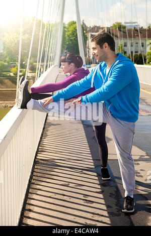 Coppia giovane stretching sul ponte, osijek, Croazia Foto Stock