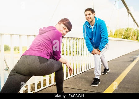 Coppia giovane stretching sul ponte, osijek, Croazia Foto Stock