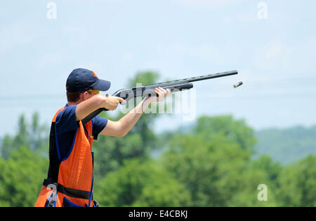 Giovane uomo skeet tiro con fucile gettando shell Foto Stock