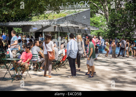 Folle di appassionati di hamburger mangiare pranzo presso lo shake Shack a Madison Square Park Foto Stock