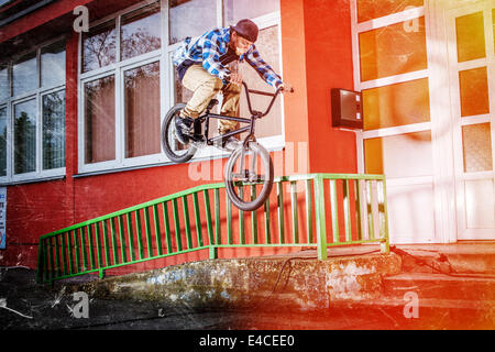 BMX biker saltando su una ringhiera Foto Stock