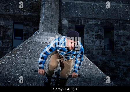 BMX biker eseguendo uno stunt su un ponte Foto Stock