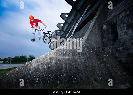 BMX biker eseguendo uno stunt su un ponte Foto Stock