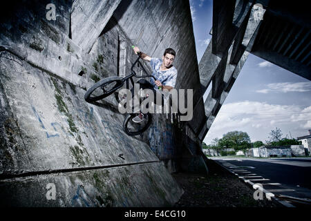 BMX biker eseguendo uno stunt su un ponte Foto Stock