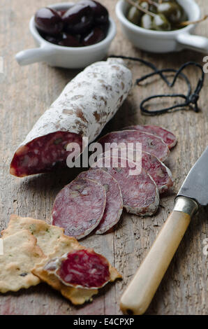 Salame su una tavola di legno Foto Stock