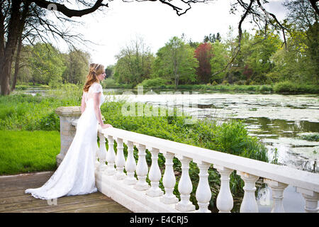 Preparazioni di nozze, sposa in abito da sposa nel parco, Dorset, Inghilterra Foto Stock