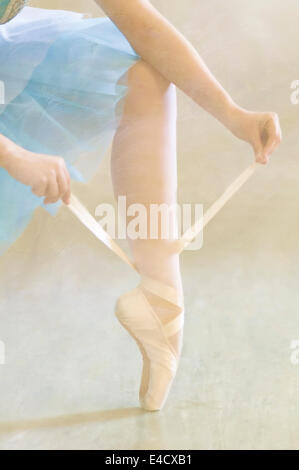 Ballerina legando il suo Balletto Pantofole Foto Stock