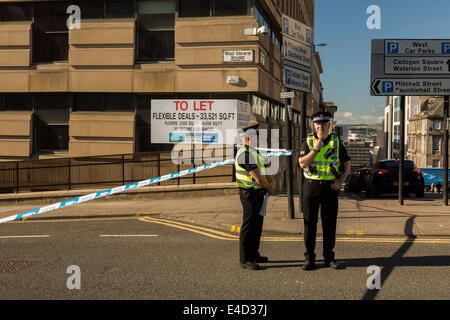 Due forze di polizia di strathclyde (UK) ufficiali in stand by a cordone in corrispondenza di un incidente di polizia, Glasgow, Scotland, Regno Unito. Foto Stock