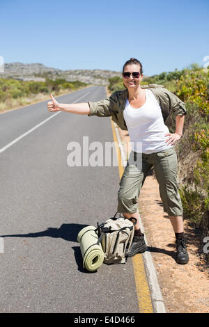 Piuttosto hitchhiker inceppato il pollice sulla strada Foto Stock