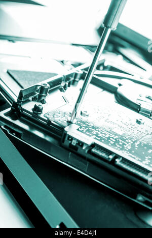 Uomo che fissa il computer o laptop o notebook con crewdriver Foto Stock