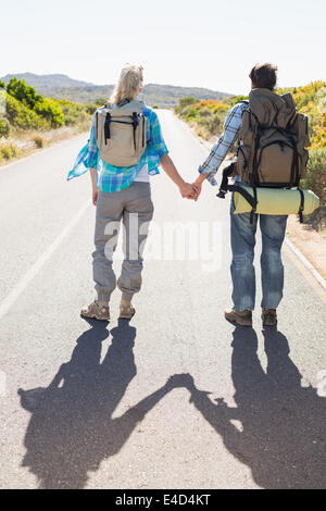 Coppia attraente permanente sulla strada tenendo le mani Foto Stock