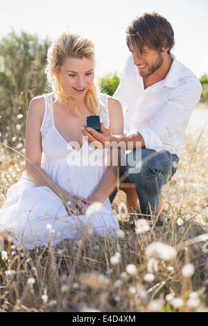 Attraente uomo propone alla sua ragazza nel paese Foto Stock