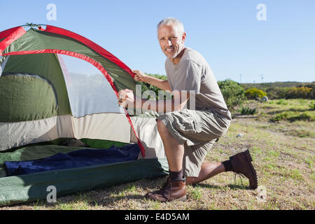 Happy camper impostando la sua tenda Foto Stock