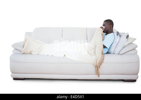 Uomo malato sdraiato sul lettino soffia il naso Foto Stock