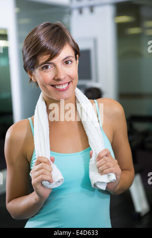 Montare brunette sorridente in telecamera con asciugamano attorno alle spalle Foto Stock