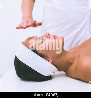 Tranquillo brunette ricevendo la terapia reiki Foto Stock