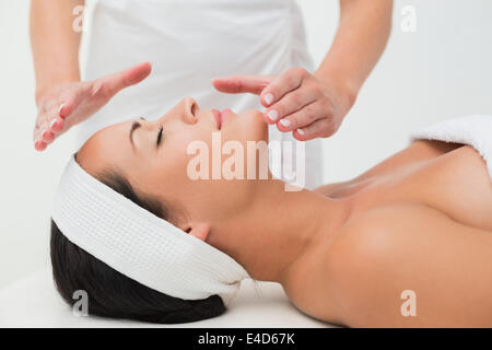 Tranquillo brunette ricevendo la terapia reiki Foto Stock