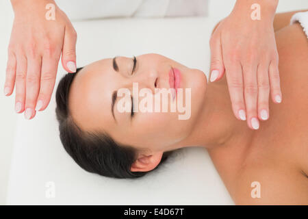 Tranquillo brunette ricevendo la terapia reiki Foto Stock