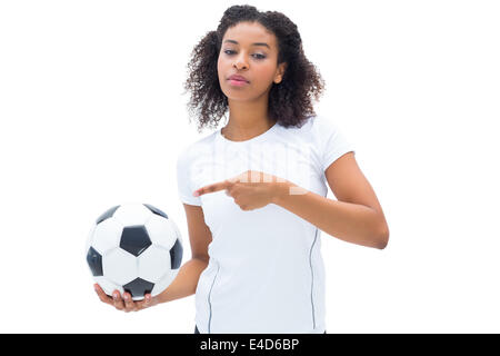 Piuttosto appassionato di calcio in bianco tenendo palla e rivolta verso di essa Foto Stock