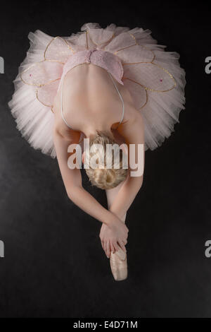 Graziosa ballerina in avanti di piegatura in rosa tutu Foto Stock