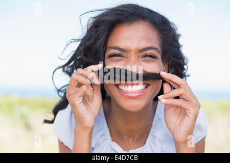 Funny donna fare i baffi con i suoi capelli Foto Stock