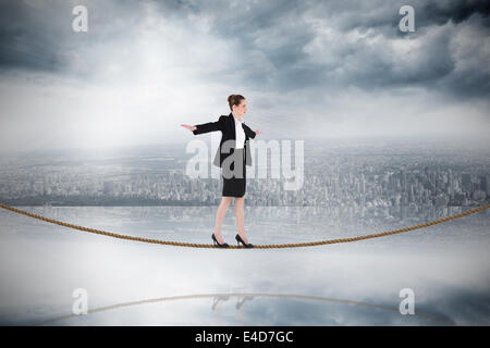 Immagine composita di imprenditrice di eseguire un esercizio di equilibrismo sulla fune Foto Stock