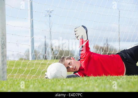 Il portiere in rosso effettuare un salvataggio Foto Stock