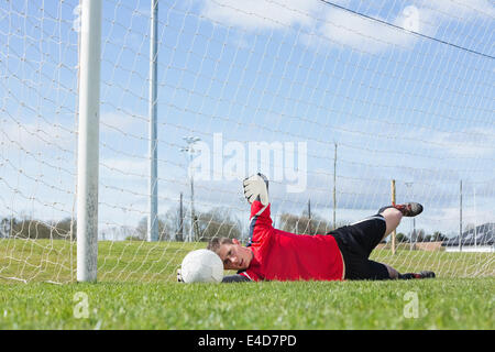 Il portiere in rosso effettuare un salvataggio Foto Stock