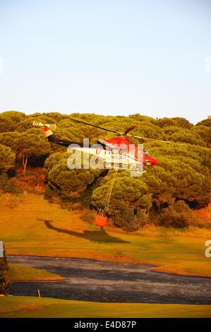 Bell 412 elicottero (registrazione N167EH) raccolta di acqua per la lotta contro gli incendi da un campo da golf lago, Cabopino Golf, Spagna. Foto Stock