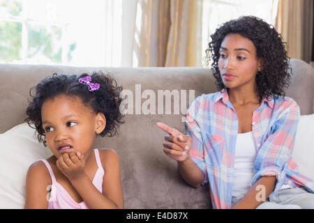 Bella madre seduta sul lettino scolding suscettibilità figlia Foto Stock