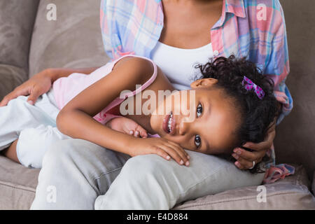 Carino figlia giacendo attraverso le madri lap Foto Stock