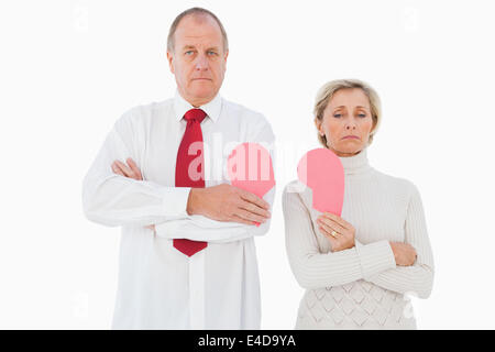 Coppia di anziani in piedi tenendo rotto cuore rosa Foto Stock