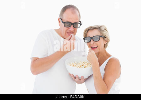 Coppia matura indossando occhiali 3d mangiare popcorn Foto Stock