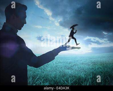 Immagine composita di imprenditore tenendo business man jumping Foto Stock