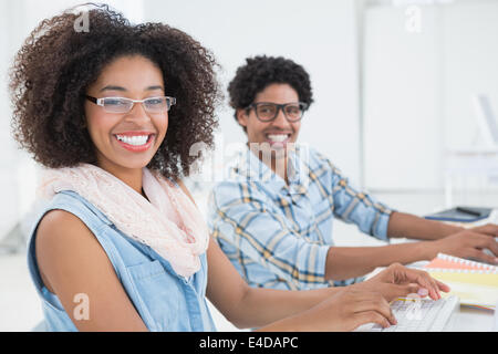 Happy design team lavora al desk insieme Foto Stock