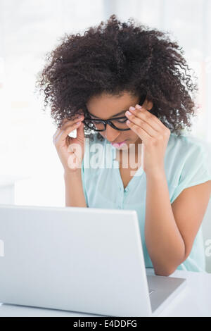 Sottolineato hipster imprenditrice lavorando sul computer portatile Foto Stock