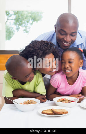 La famiglia felice avente insieme per la prima colazione al mattino Foto Stock