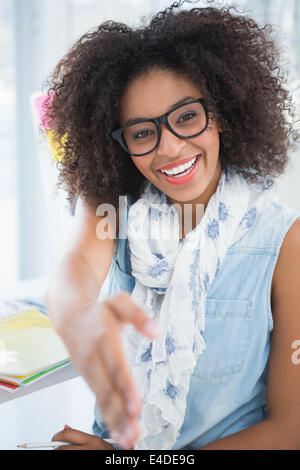 Piuttosto designer sorridente in telecamera offrendo la sua mano Foto Stock