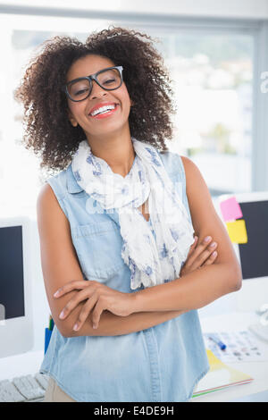 Piuttosto designer sorridente in telecamera con le braccia incrociate Foto Stock