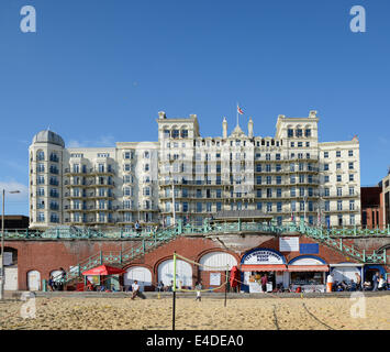 Il Grand Hotel sul lungomare di Brighton. East Sussex. In Inghilterra. Con le persone sul lungomare e la spiaggia Foto Stock