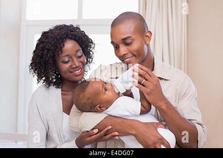 Genitori felici alimentando il loro bambino una bottiglia Foto Stock