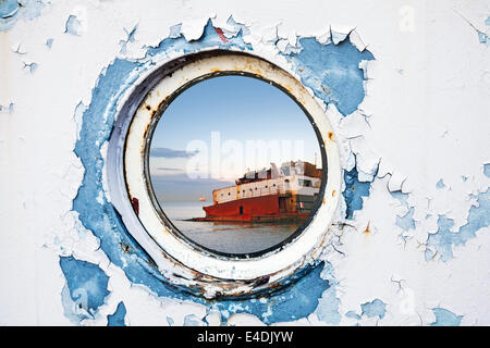 Relitto di nave dietro oblò rotondo in bianco e blu la parete Foto Stock